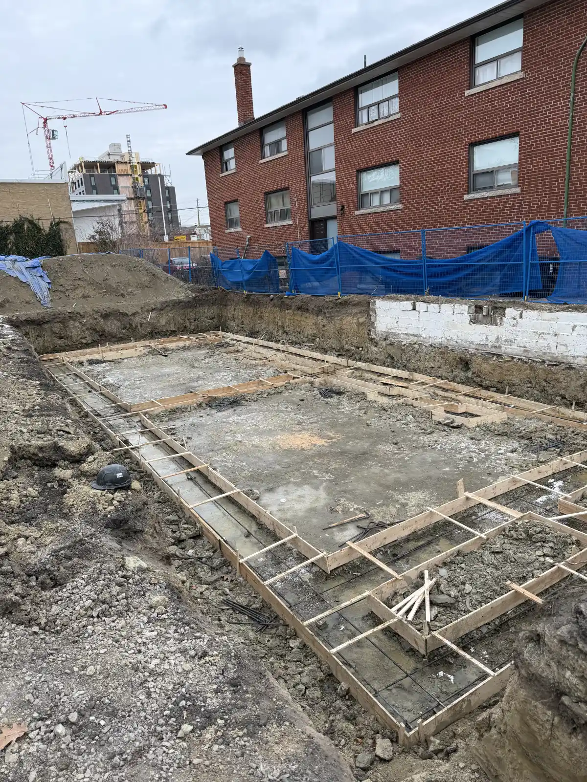 Foundation footing forms and reinforcing steel within an excavated urban lot