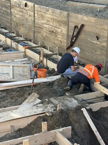 Crew working among timber concrete forms at NEIGHBOUR 1