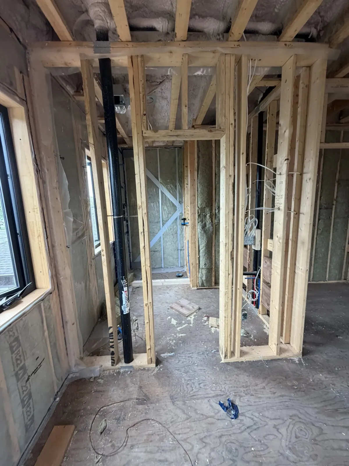 Timber framing, insulation, plumbing and electrical rough-ins inside a home under construction