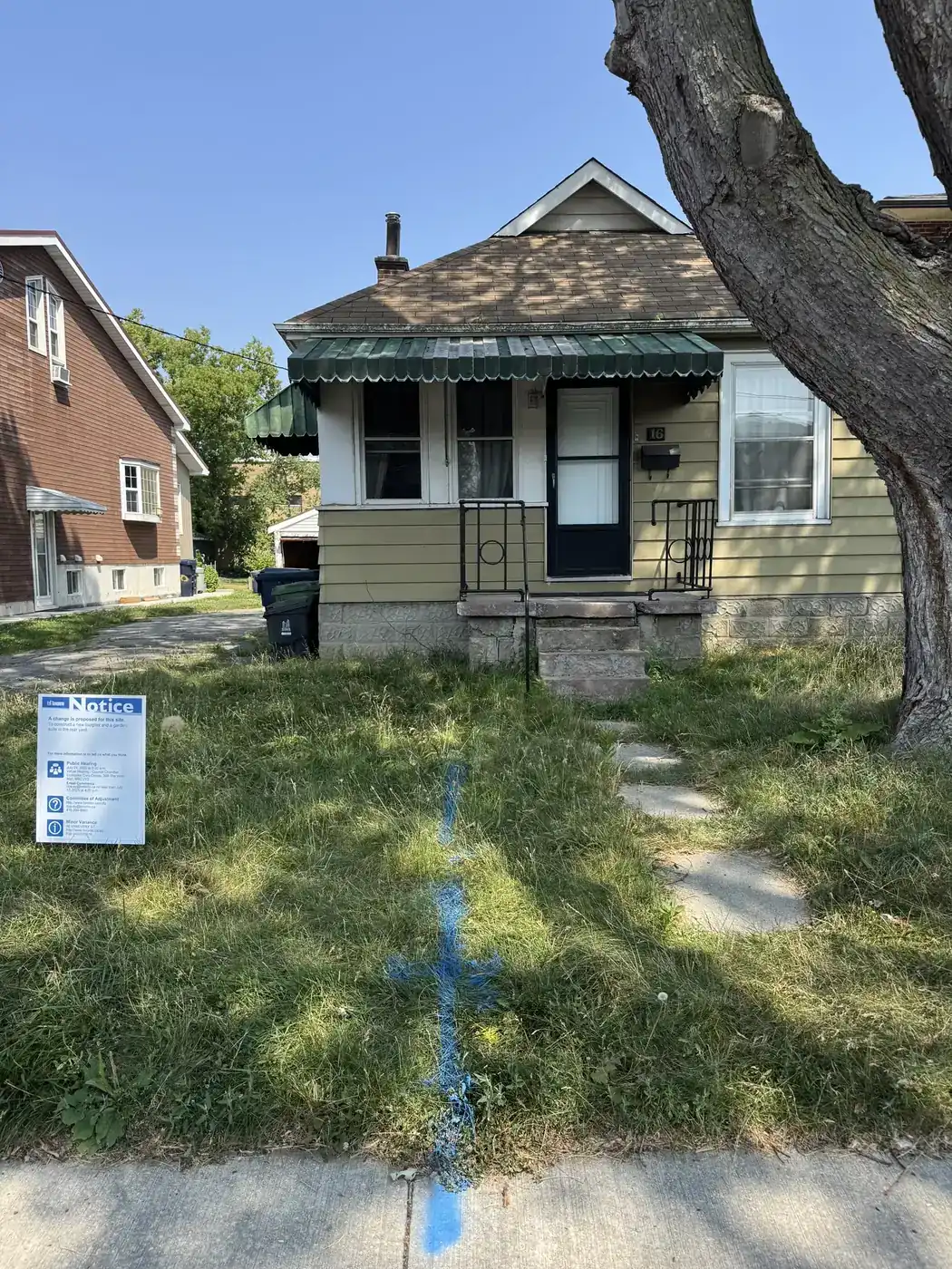 Existing Toronto house with a planning notice posted beside the front walk